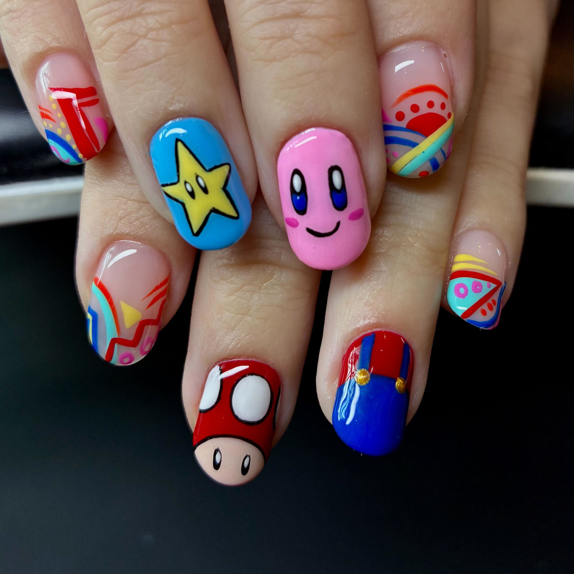 Short nails with hand-painted video game characters, stars and mushrooms, all freehand