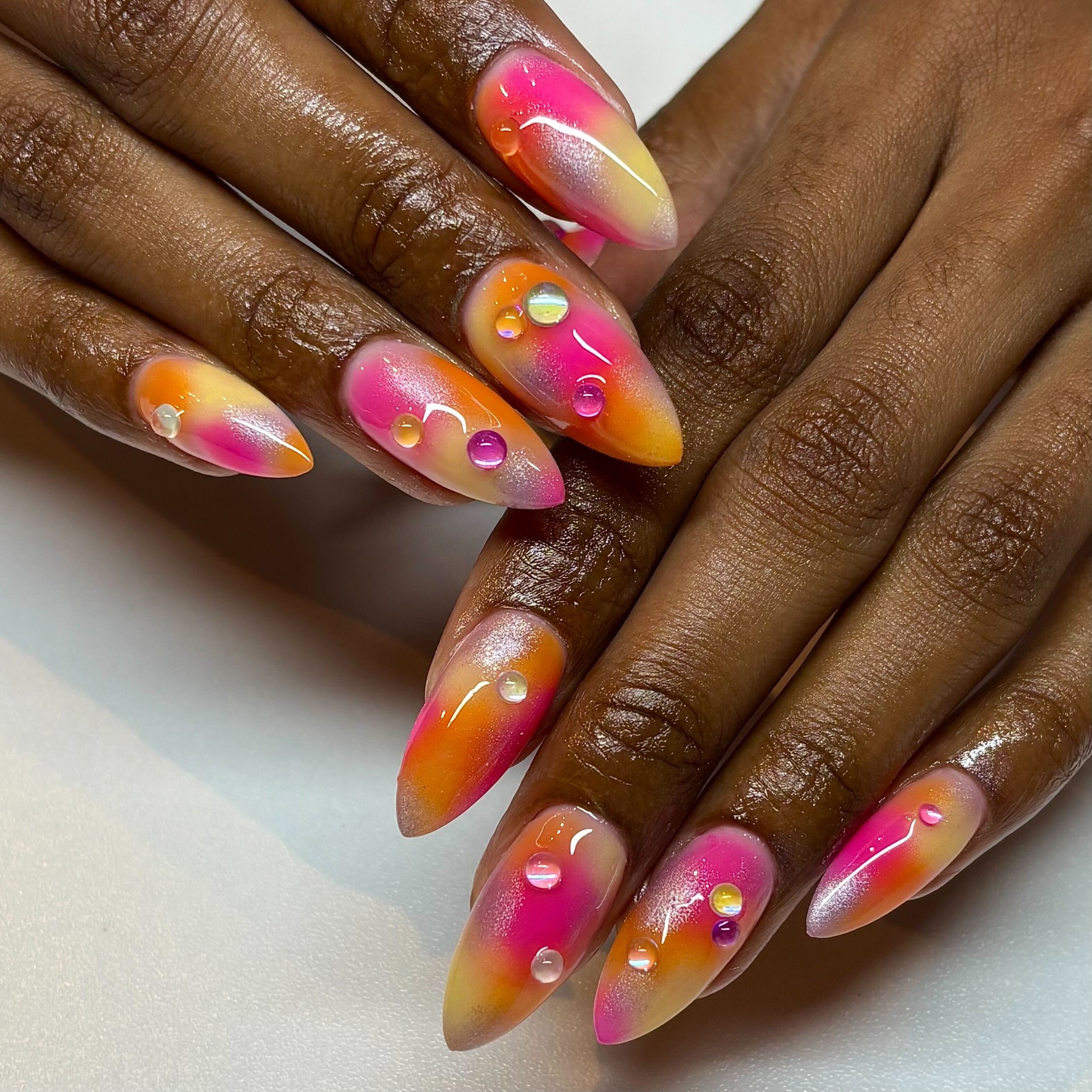 Pink and orange airbrushed stiletto nails with gems