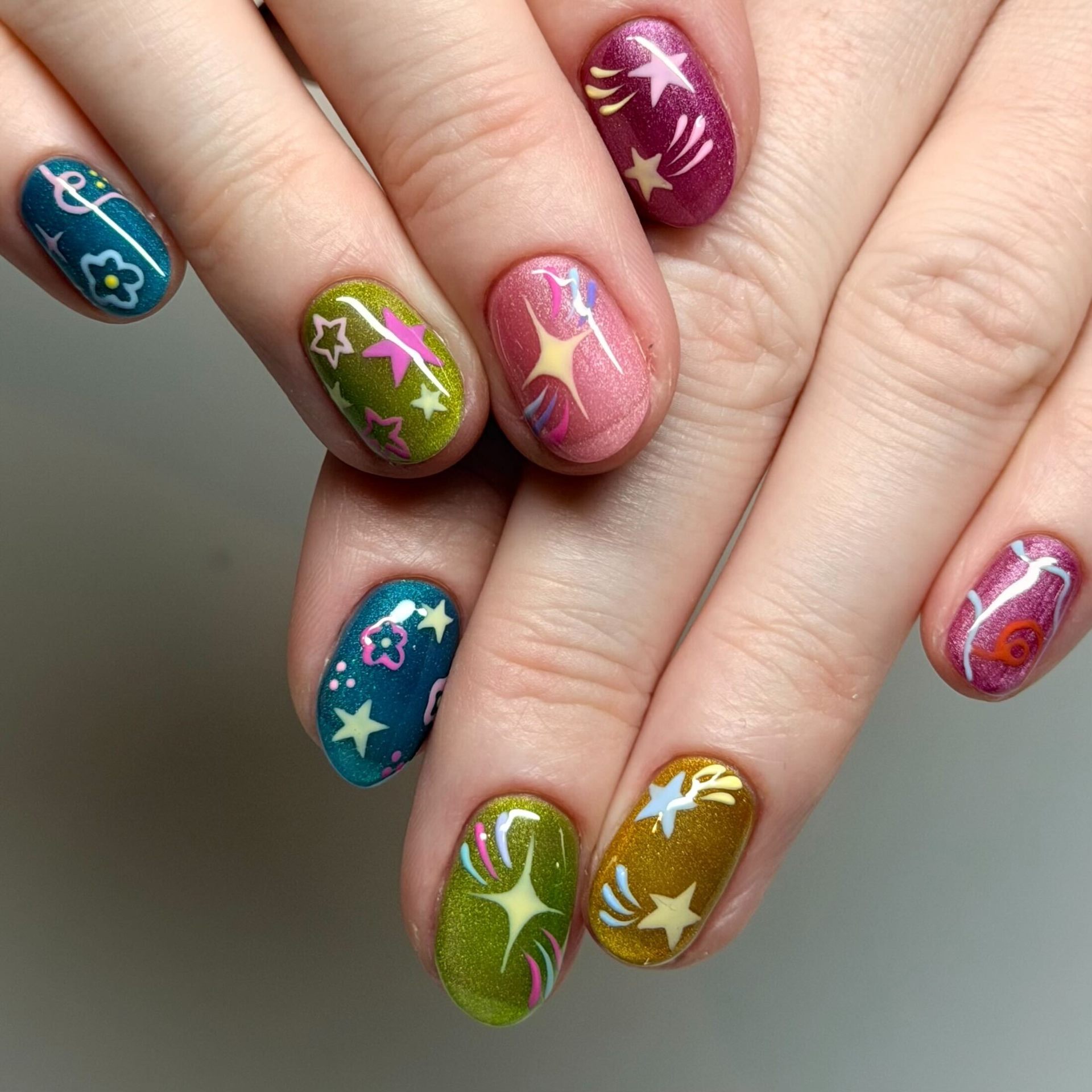 Hand-painted stars and floral nail art by 'Cure Studios
