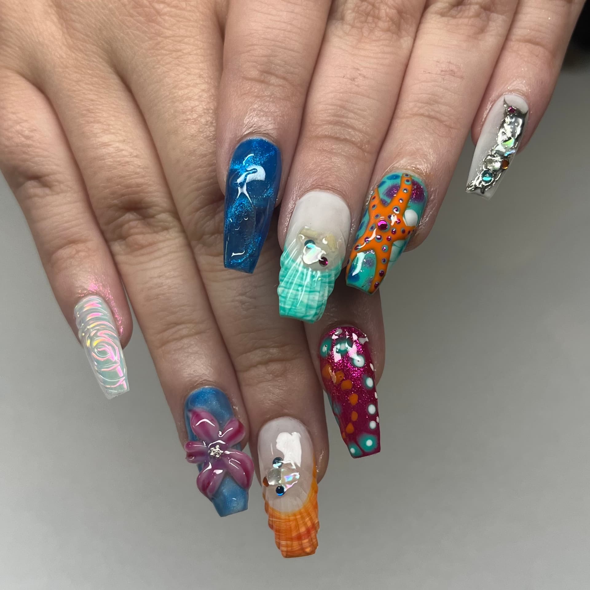 Long coffin nails with a hand-painted under the sea set: starfish, shells, 3D florals and gems