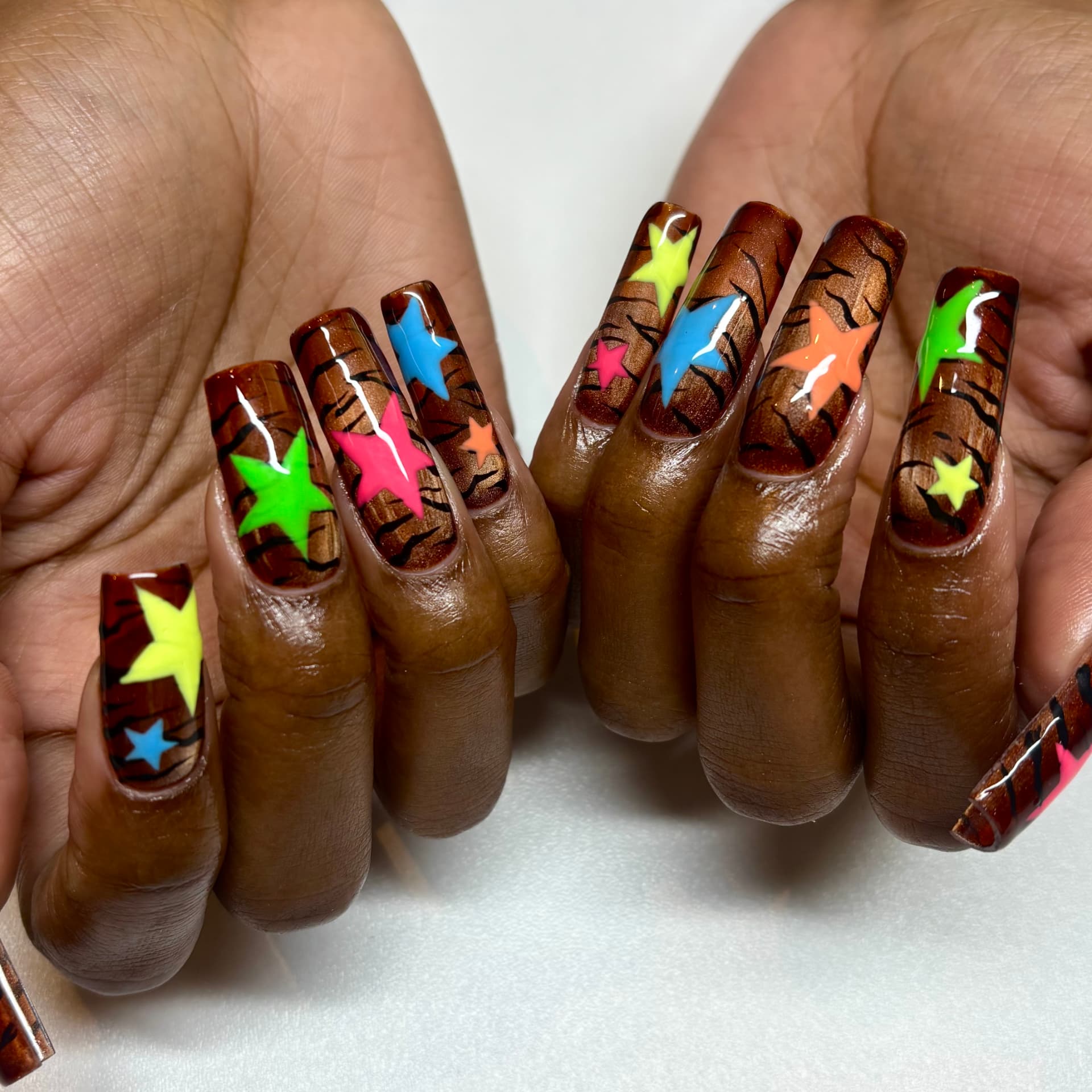 Long coffin nails in hand-painted tortoise shell with neon freehand stars
